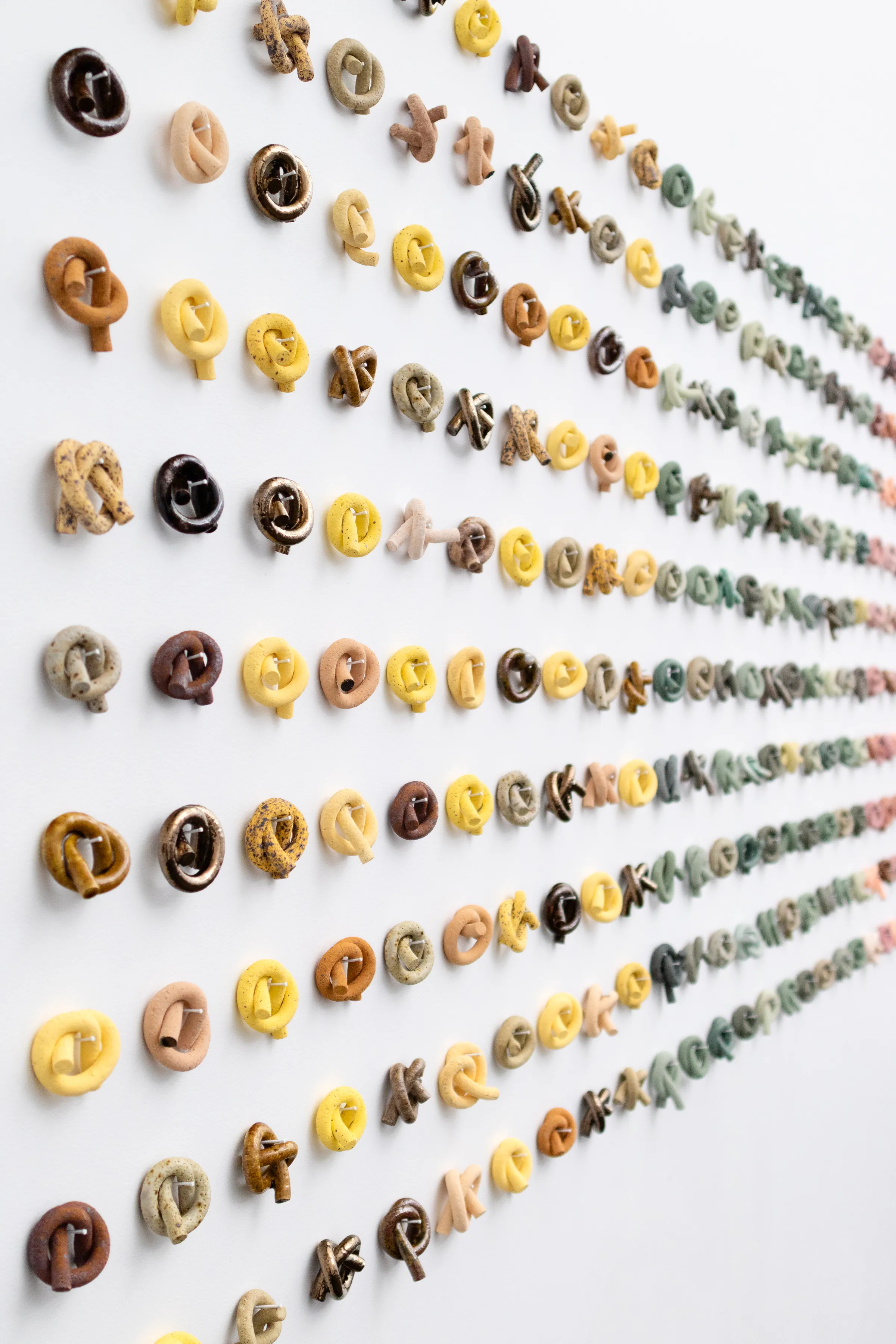 Not Wall No. 4 (detail), rows of small glazed ceramic knots on a white wall at Haydens Gallery
